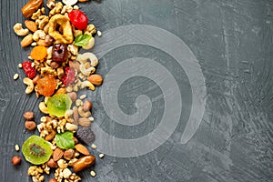 Various dried fruits and mix nuts on a gray stone or slate background.  The concept of the Jewish holiday Tu Bishvat. Flat lay,