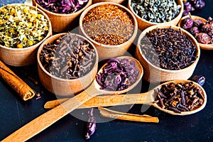 Various dried tea leaves in wooden bowl