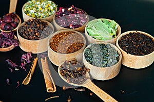 Various dried tea leaves in wooden bowl