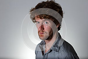 Young man serious look on gray background