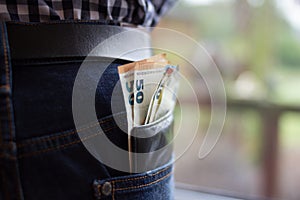 Various euro banknotes in a colourful Jeans pocket. Close up Money in pocket.