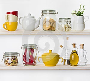 Various food ingredients and utensils on kitchen shelves isolated