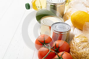 Various foodstuff on white wooden table. Food donation