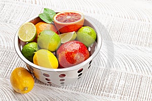 Various fresh citrus fruits in colander. Bood orange, lime, lemon