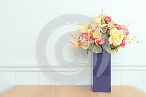 Various fresh flowers arrangement in vase on wooden table