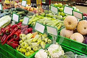 Various fresh fruits and vegetables in boxes on the shelves of the store, at the vegetable market.