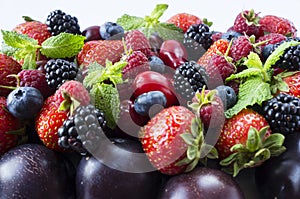 Various fresh summer berries and fruits. Ripe strawberries, blackberries, blueberries, raspberries, red berries and plum.