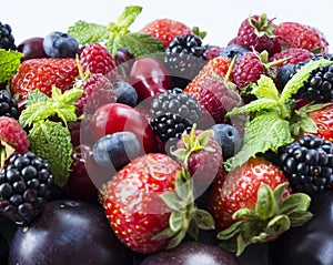 Various fresh summer berries and fruits. Ripe strawberries, blackberries, blueberries, raspberries, red berries and plum. Top view