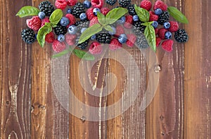 Various fresh summer berries on wooden background.