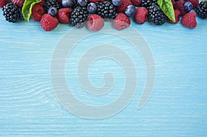 Various fresh summer berries on wooden background.