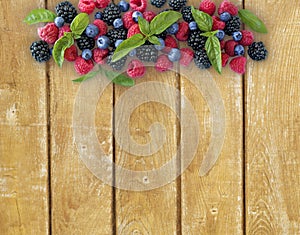 Various fresh summer berries on wooden background.