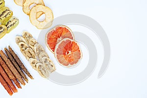 Various fruit chips and pastila on white background copy space. Assorted dehydrated apple, banana, kiwi fruit chips - healthy