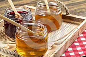 Various fruit marmalade jams in jars top view. Honey, apricot jam and strawberry jam in jars