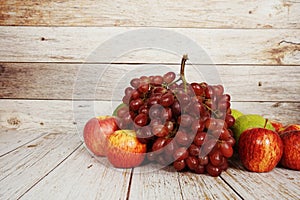 Various of fruits with Red grape, red apple and green orange on wooden background