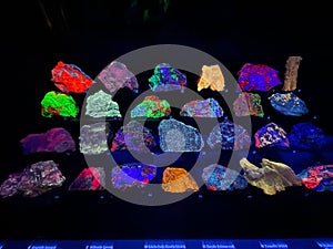 Various gem stones glow under fluorescent light