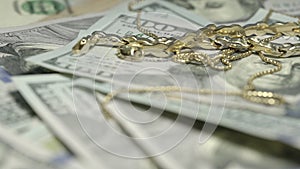 Various golden accessories fall on rotating dollar bills