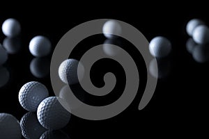 Various golf balls isolated on black background.