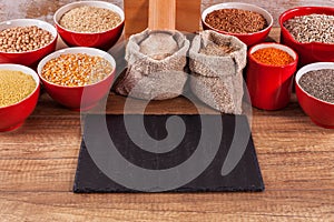 Various grains and seeds around a tabletop mill