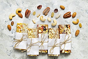 Various granola bars with nuts, dry fruits on gray background