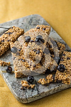 Various granola bars on table background. Cereal granola bars. Superfood breakfast bars with oats, nuts and berries, close up