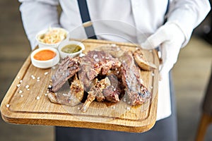 Various grilled meat set with Pickled cabbage and two sauces. Serving on a wooden Board. Barbecue restaurant menu, a