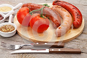 Various grilled sausages with condiments and tomatoes