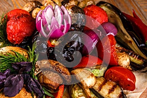 Various grilled vegetables on a round wooden Board. Tomatoes, zucchini, onions, eggplant, mushrooms, paprika