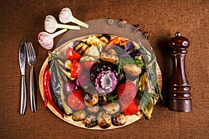 Various grilled vegetables on a round wooden Board. Tomatoes, zucchini, onions, eggplant, mushrooms, paprika