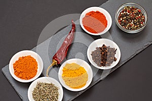 Various ground spices and herbs on stone cutting board