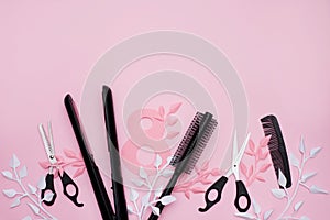 Various hair dresser tools and paper leaves on pink background with copy space, World Women`s Day, March 8th