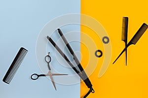 Various hair styling devices on the color blue, yellow paper background, top view