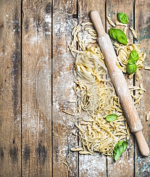 Various homemade fresh uncooked Italian pasta and plunger