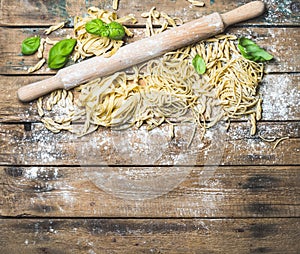 Various homemade fresh uncooked Italian pasta and plunger