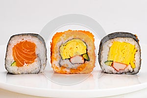 Various homemade japanese style sashimi sushi roll in white ceramic plate