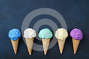 Various ice cream cones on black table flat lay