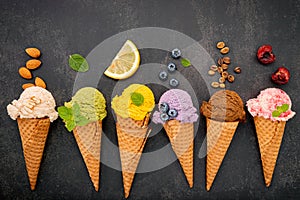 Various of ice cream flavor in cones blueberry ,green tea ,pistachio ,almond ,orange and cherry setup on dark stone background .