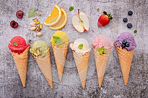 Various of ice cream flavor in cones blueberry ,green tea ,pistachio ,almond ,orange and cherry setup on dark stone background .