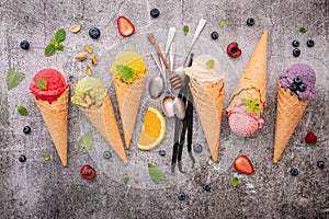 Various of ice cream flavor in cones blueberry ,green tea ,pistachio ,almond ,orange and cherry setup on dark stone background .