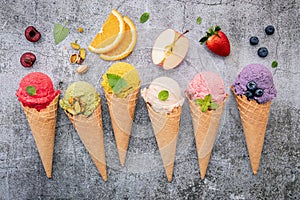 Various of ice cream flavor in cones blueberry ,green tea ,pistachio ,almond ,orange and cherry setup on dark stone background .