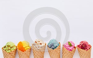 Various of ice cream flavor in cones blueberry ,strawberry ,pistachio ,almond ,orange and cherry setup on white wooden background