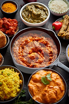 Various Indian dishes on a table. Spicy chicken Tikka Masala in iron pan photo