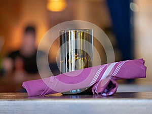 Various items on a restaurant table, napkins, candle, diners