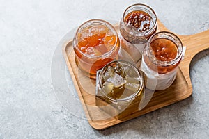 Various Jar of Fruit Jams Fig, Quince, Bergamot Citrus, Watermelon on Wooden Tray / Marmalade. photo
