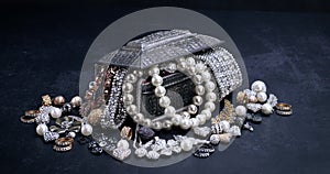 Various jewelry in a silver box on black background