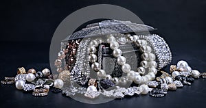 Various jewels in a silver box on black background