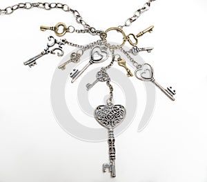 various keys attached to a chain on white-grey isolated background