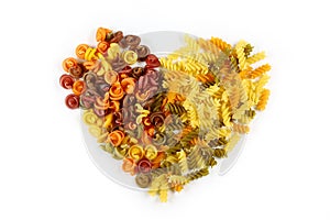 Various kinds of colored raw Italian pasta on a white background, top view, valentine heart from food, opening to the holiday, set
