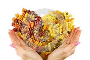 Various kinds of colored raw Italian pasta on a white background, top view, valentine heart from food, opening to the holiday, set