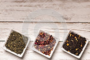 Various kinds of dry tea in bowl on table