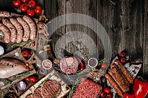Various kinds of grill and bbq raw meats. Chicken, steak, sausages, minced beef meat kebabs, pork with herbs, spices on wooden photo
